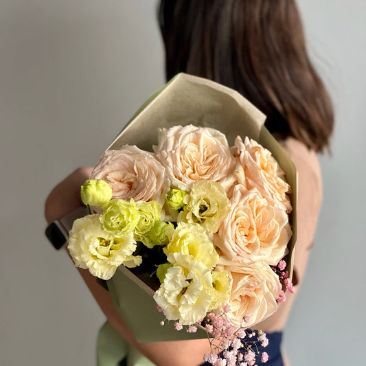 Bouquet of flowers held by a person with a blurred background
