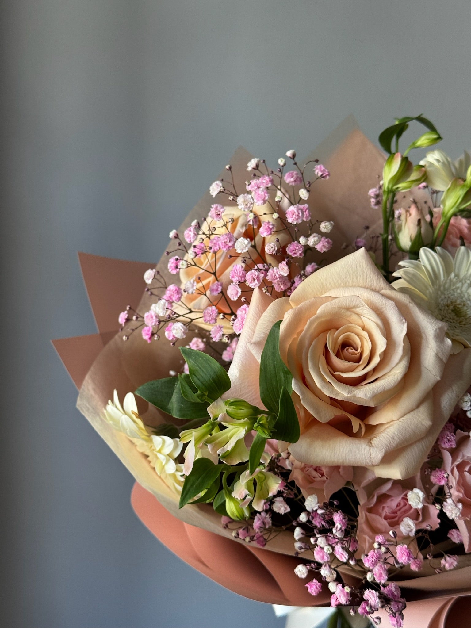 Bouquet of flowers with pink and white roses on a gray background