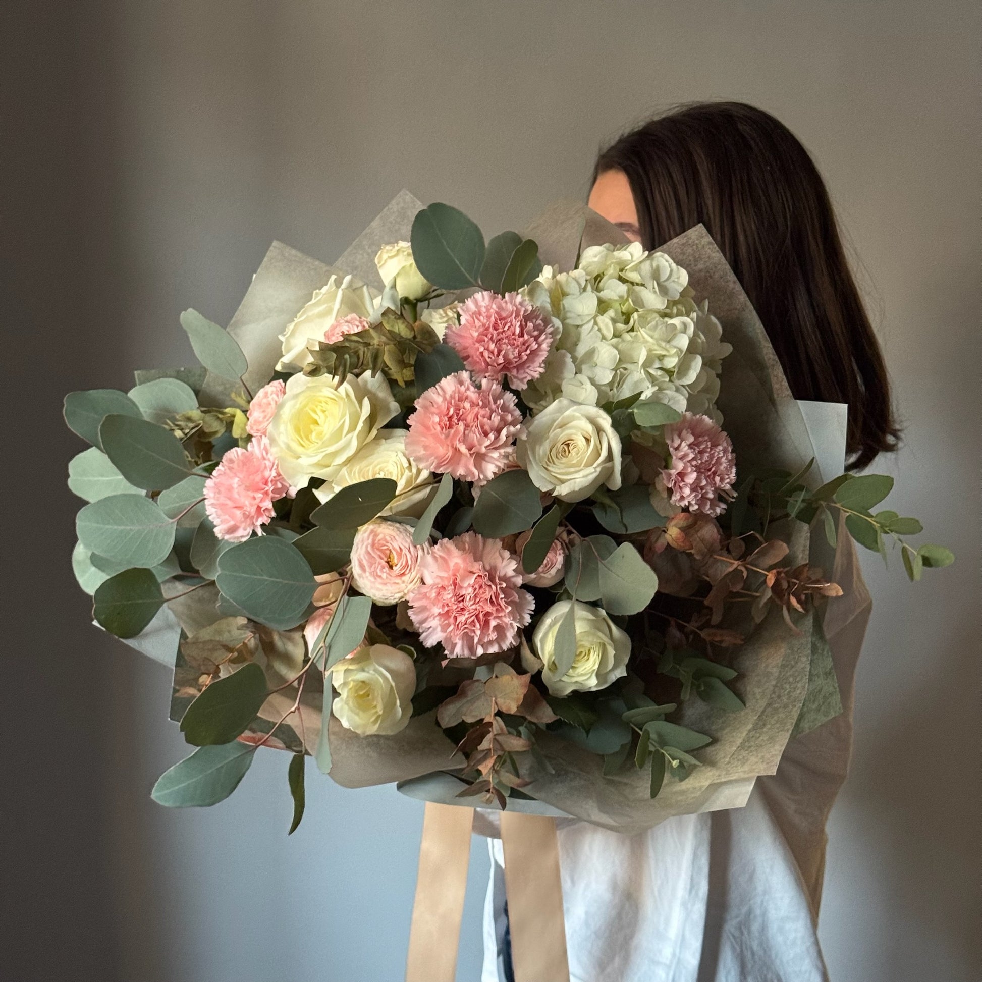 Buchet Pieces of Blossom cu trandafiri albi, garoafe roz și eucalipt