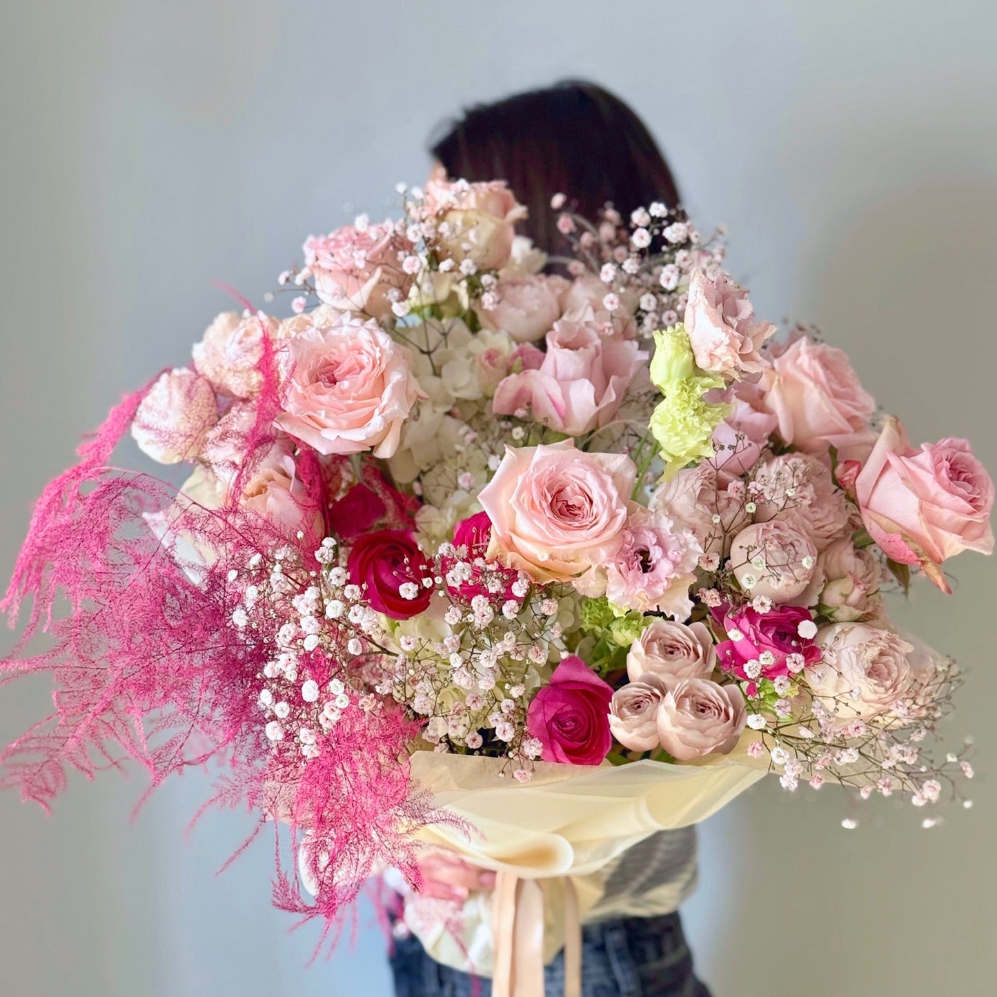 Bouquet of pink and white flowers with a blurred person in the background