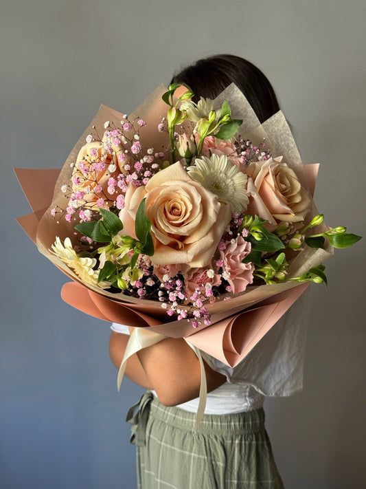 Person holding a bouquet of flowers against a neutral background