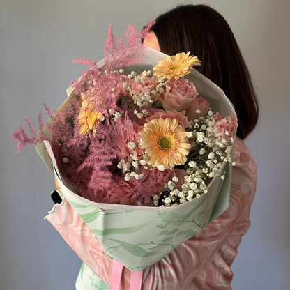 Person holding a bouquet of flowers with a plain background