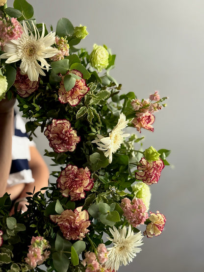 Coroana funerară of flowers with a blurred person in the background
