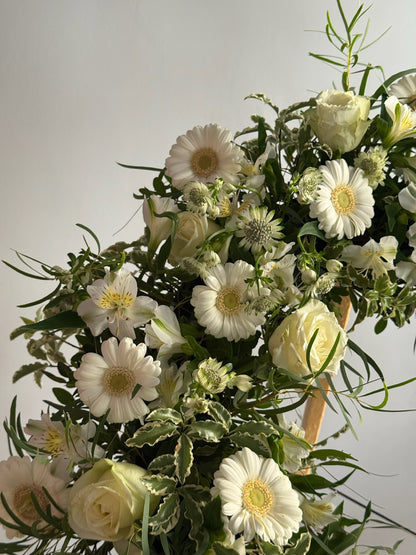 Bouquet of white and green flowers with greenery on a light gray background