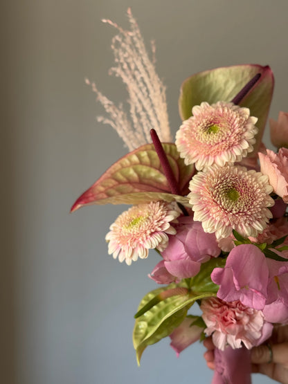 Pink flowers in bouquet on grey background 