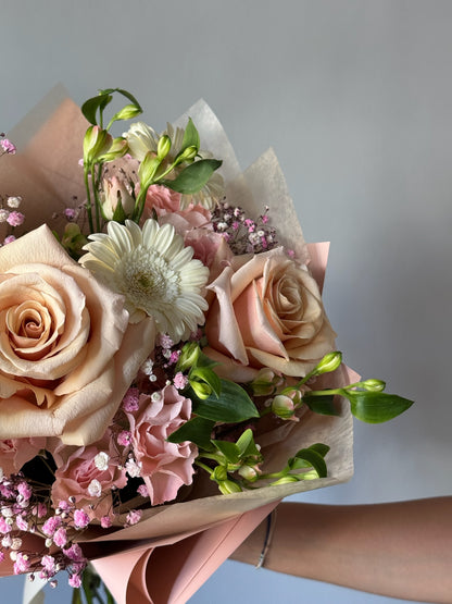 Bouquet of flowers held by a person against a neutral background