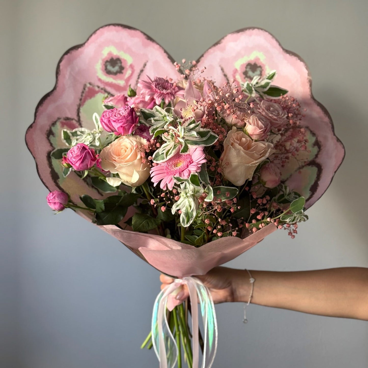 Buchet cu flori roz și verdeață fină in ambalaj in forma de fluture
