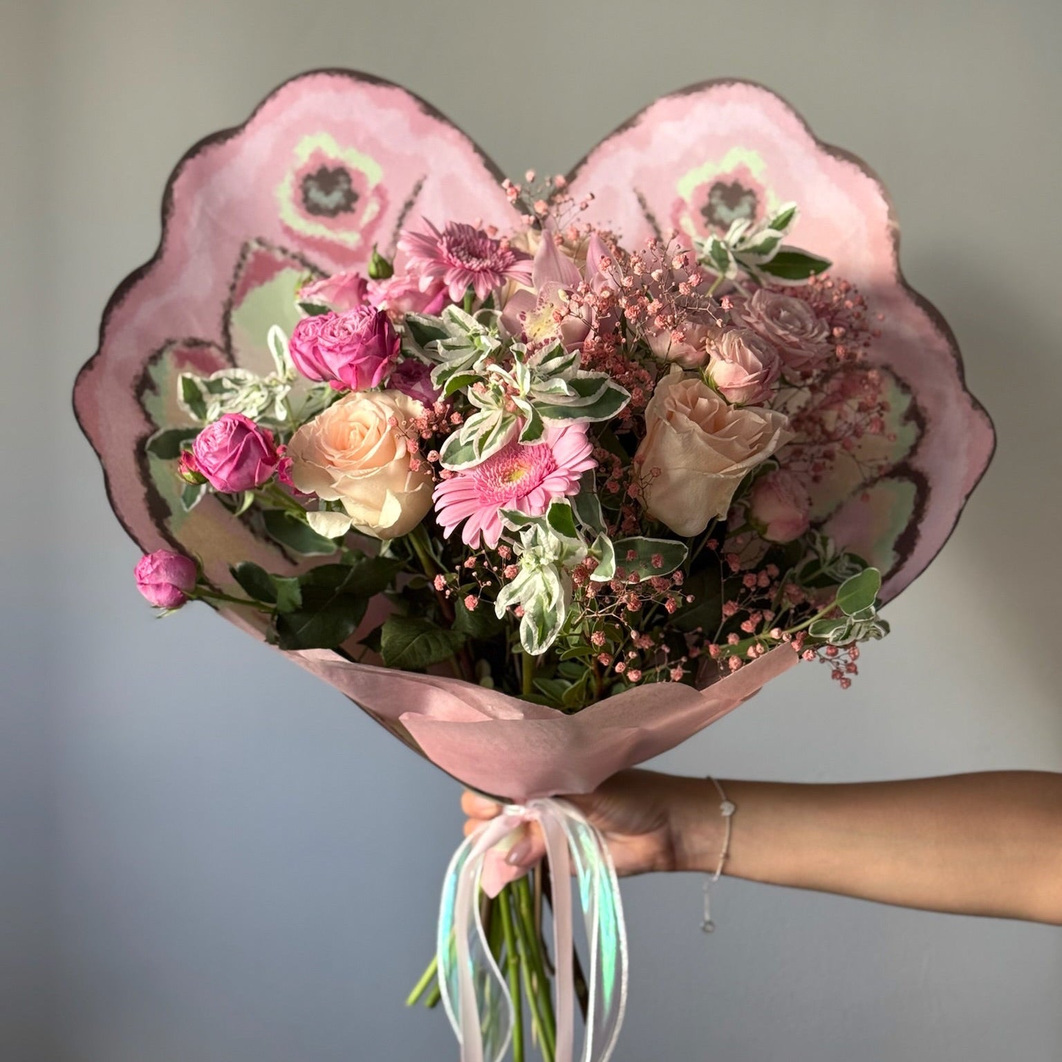 Buchet cu flori roz și verdeață fină in ambalaj in forma de fluture