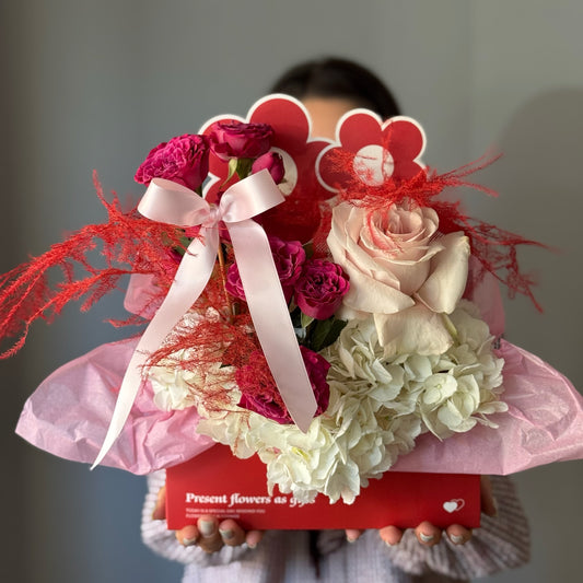     Aranjament Velvet Valentine în cutie tip plic, cu flori roșii, albe și roz.