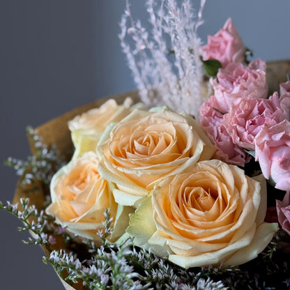 Yellow and peach roses on grey background 