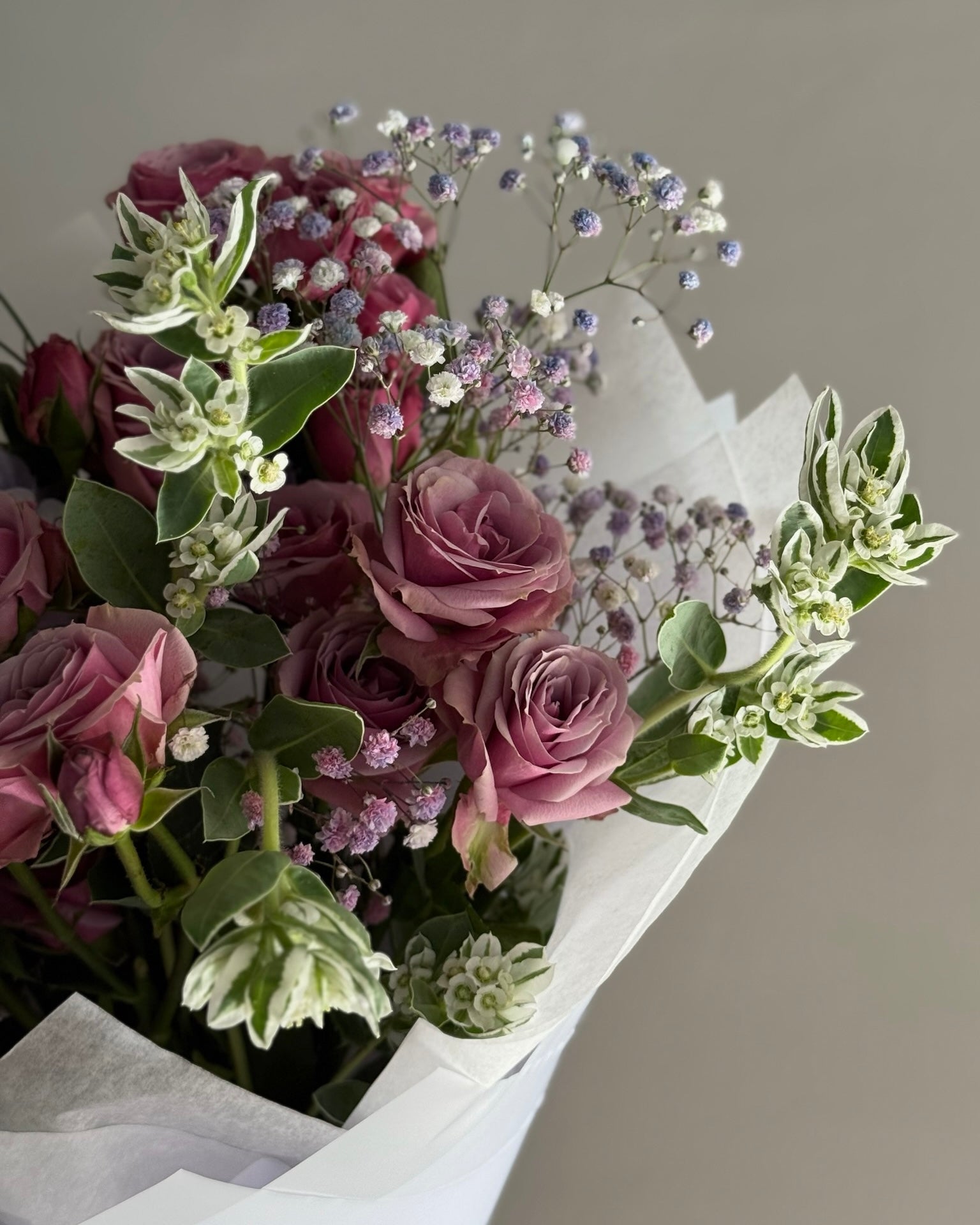 Bouquet of pink roses and greenery on a neutral background